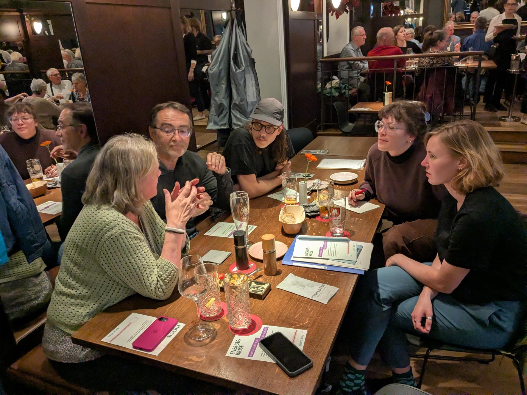 Foto zeigt Menschen an einem Tisch sitzend im Gespräch